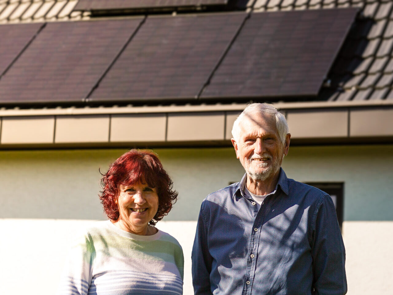 Nahaufnahme Zwei Kunden stehen vor einem Haus mit PV-Anlage in Remseck